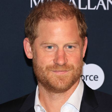 Prince Harry smiling in front of a step and repeat