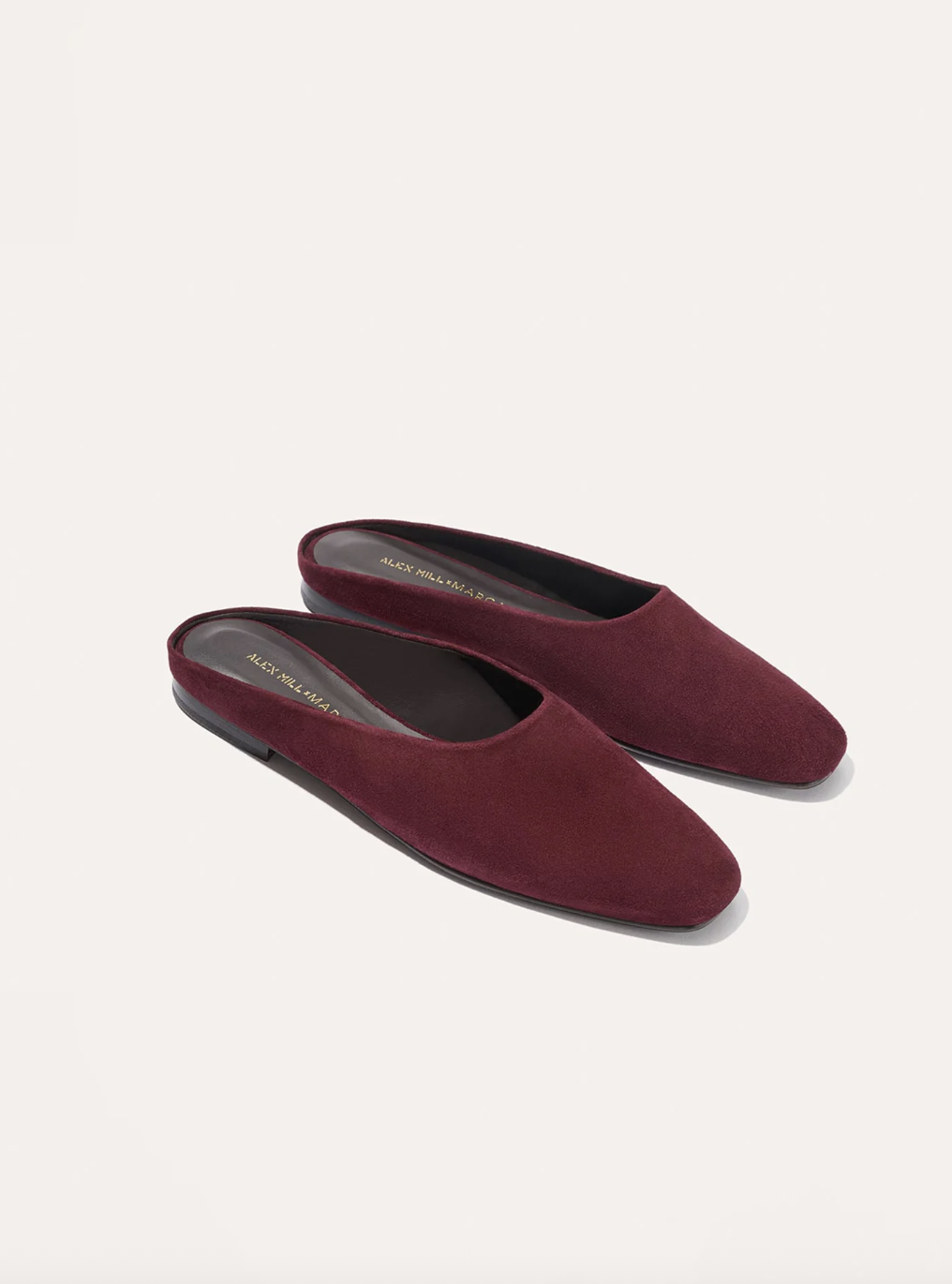 a pair of shoes in front of a plain wall