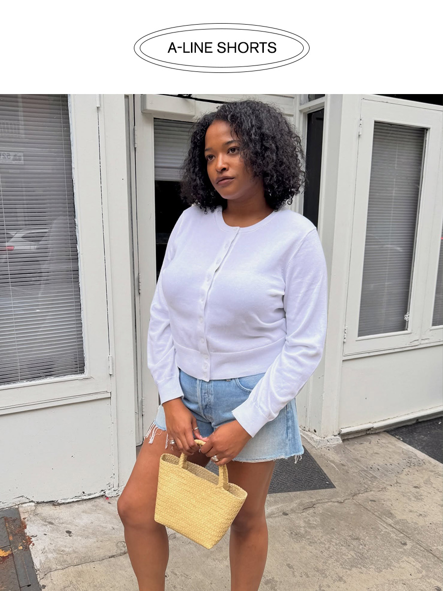 Influencer wearing cut-off denim shorts with a white cardigan
