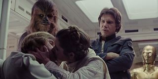 Chewie, Han Solo, and C-3PO watch Luke and Leia kiss in The Empire Strikes Back.