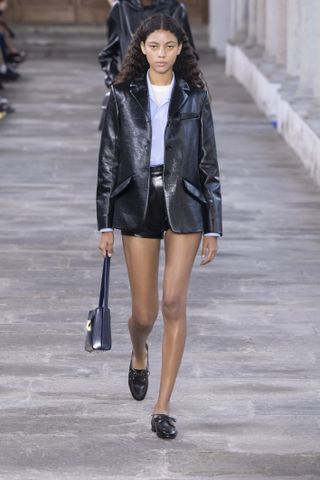 a model on the Bally runway wearing a pair of microshorts and a blazer with boat shoes