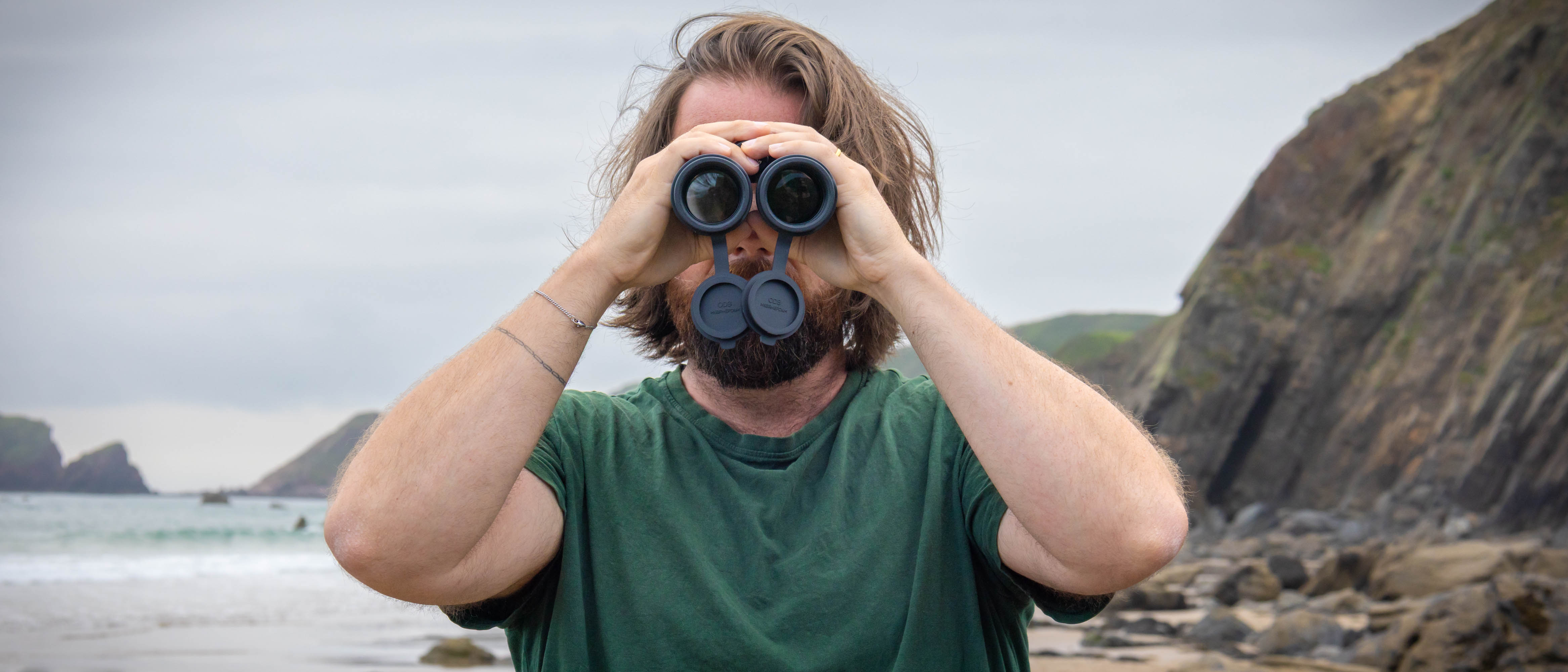 A male using the Nikon Monarch M7 8x42 binoculars, looking directly at the camera.