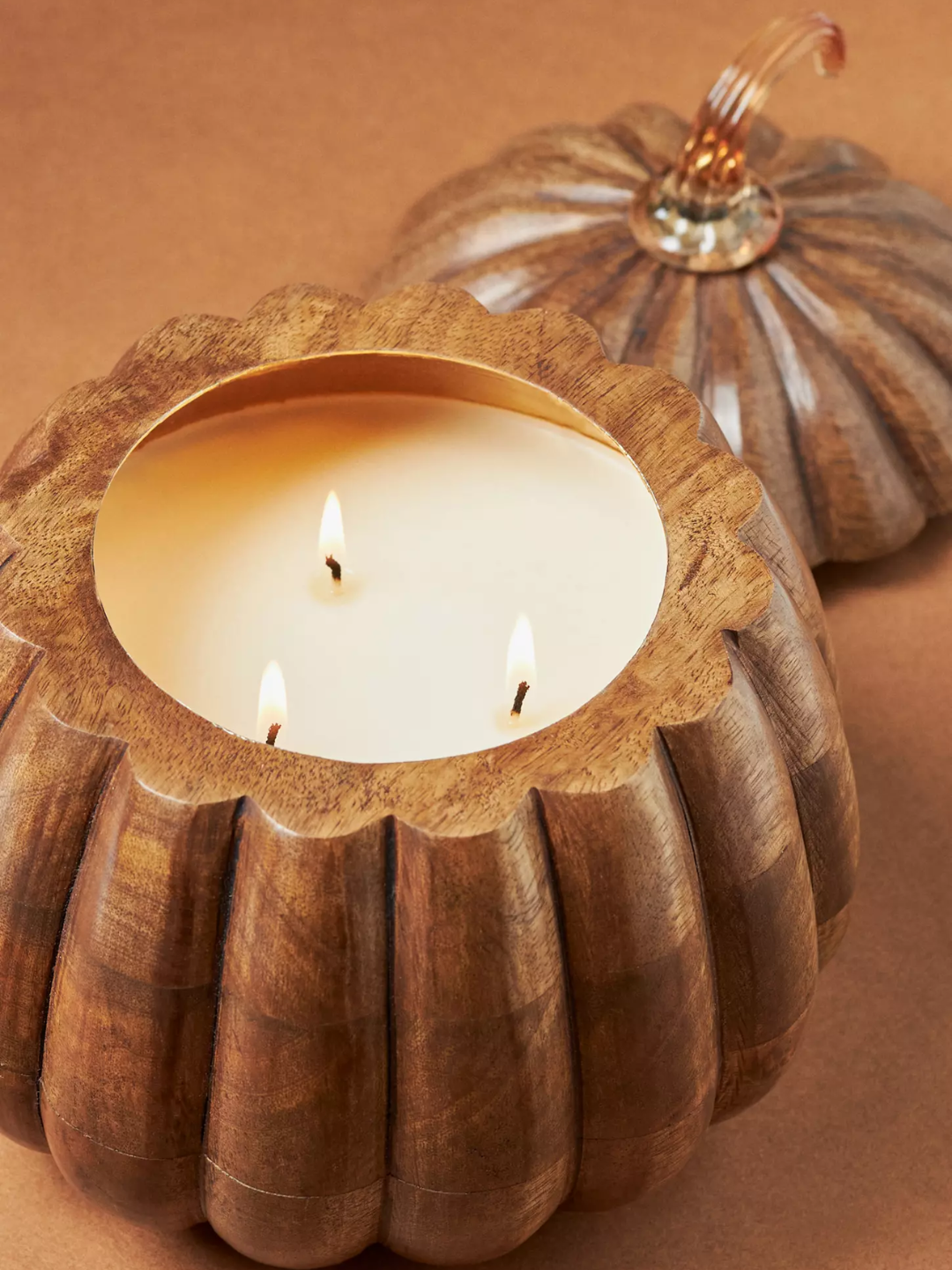 A wood pumpkin-shaped pumpkin spice and black walnut candle from Anthropologie