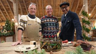 Steve Fletcher, Steven Roy Alvey and Jay Blades (L-R) stood behind Steven's mechanical christmas cake for The Repair Shop at Christmas 2023