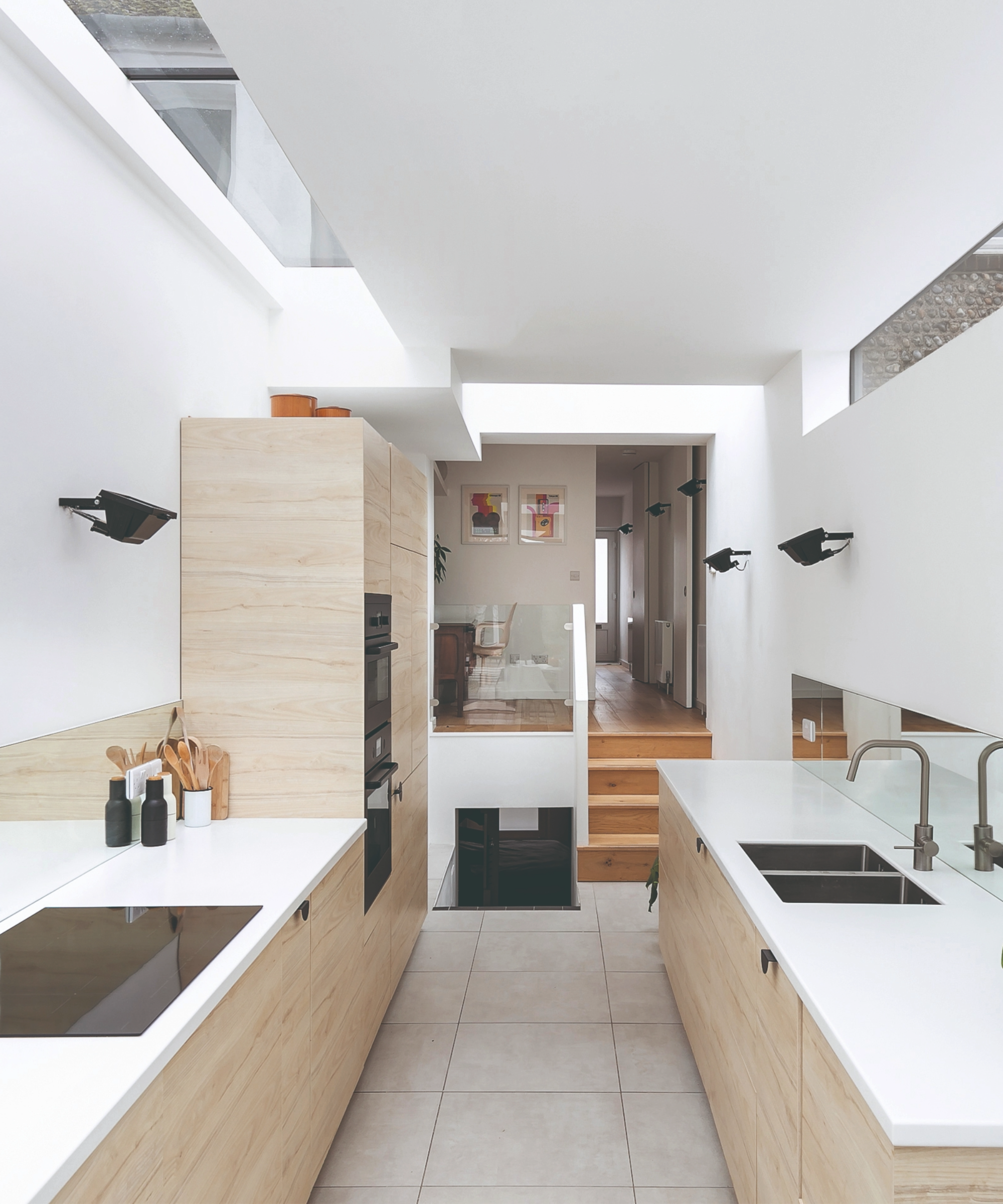 Kitchen with white worktops and wooden cabinets and skylights