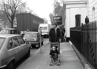 Lady Diana Spencer takes her young charge Patrick Robertson for his daily outing in the Eaton Square district of London during her time as a nanny, November 1980. She wears a green Loden wool coat. Only weeks later, her engagement to the Prince of Wales was announced. (Photo by John Hoffman/Princess Diana Archive/Getty Images)