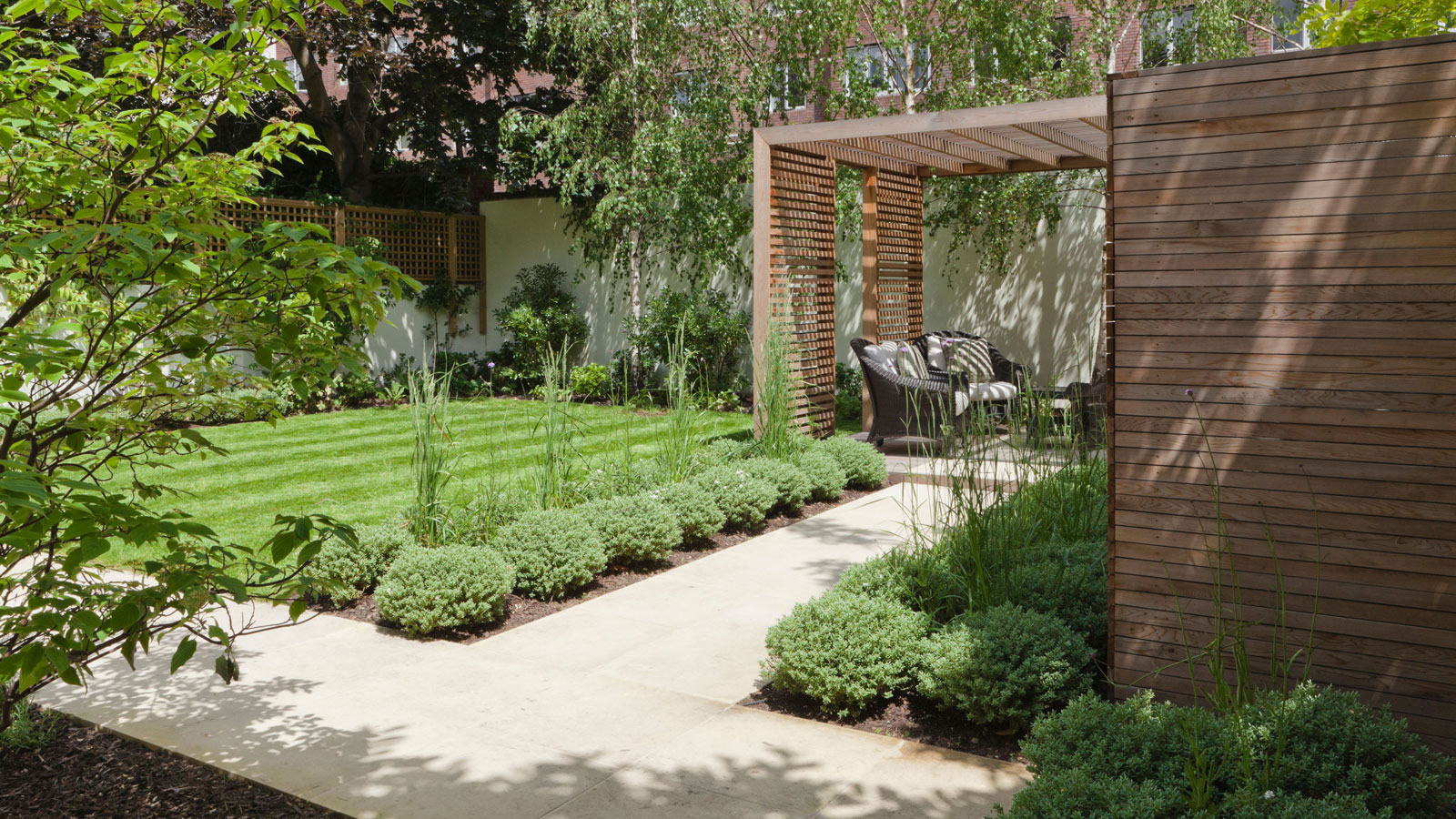 L-shaped garden design with lawn, path, trees and pergola