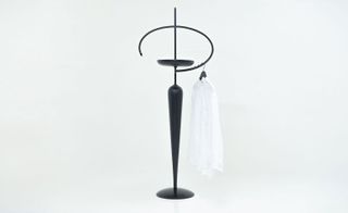 Black steel-framed furniture with a white shirt hanging on it