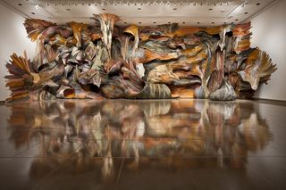 Installation at the Rice Gallery. The whole far wall is covered with the installation, that carries over to the ceiling and the two other walls. It's colorful and has many different shapes. It resembles a cave wall.