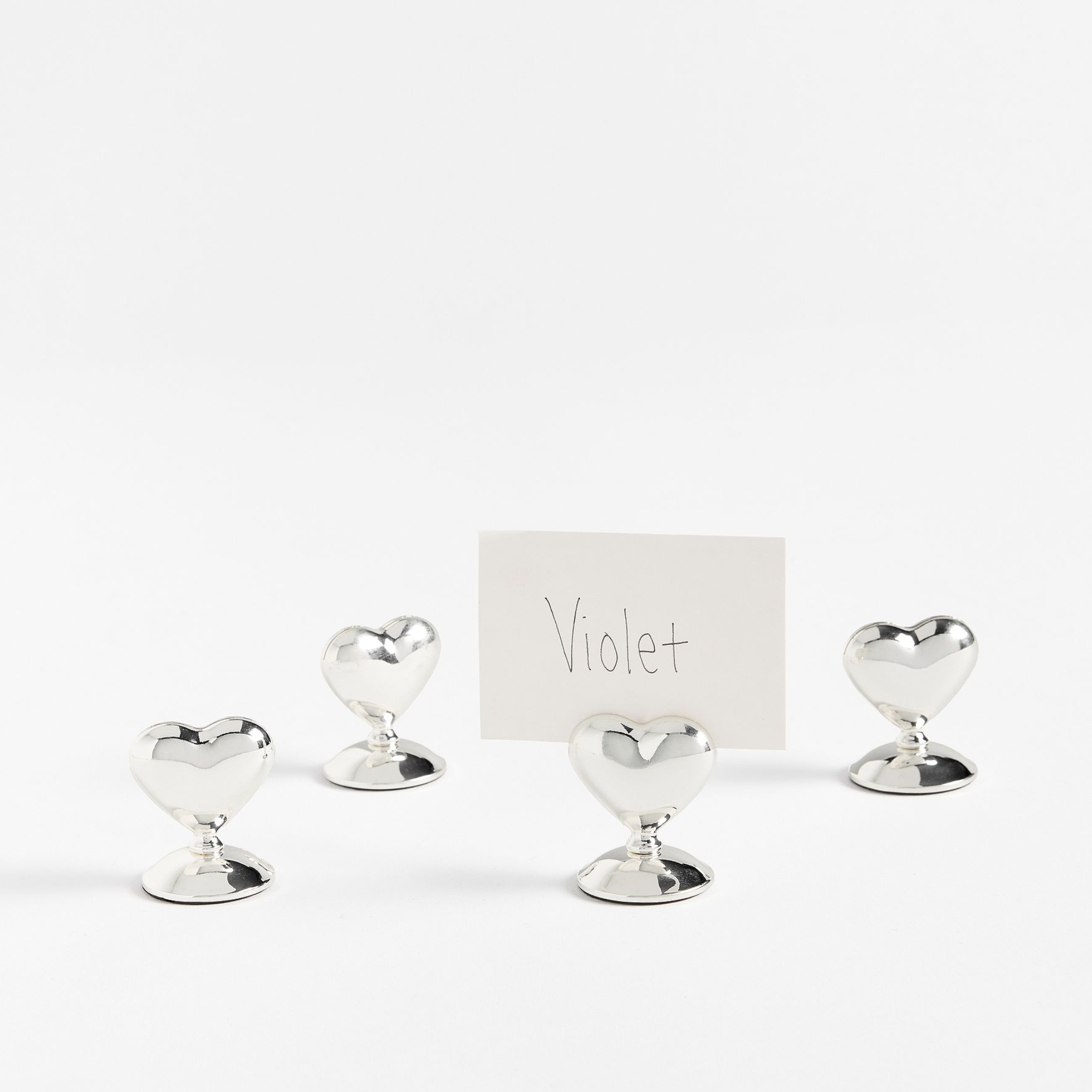 four metal heart-shaped place card holders