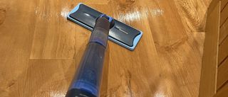 mop being used to clean wooden floor