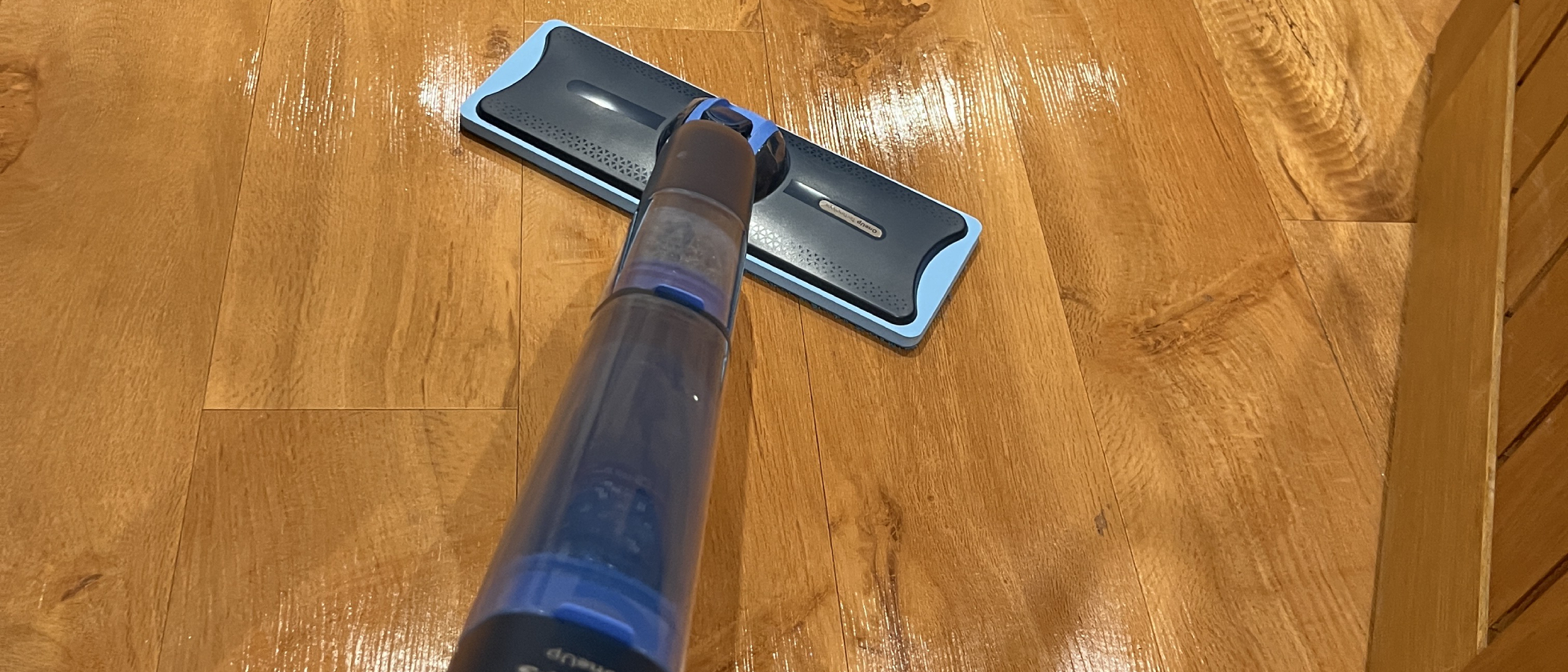 mop being used to clean wooden floor
