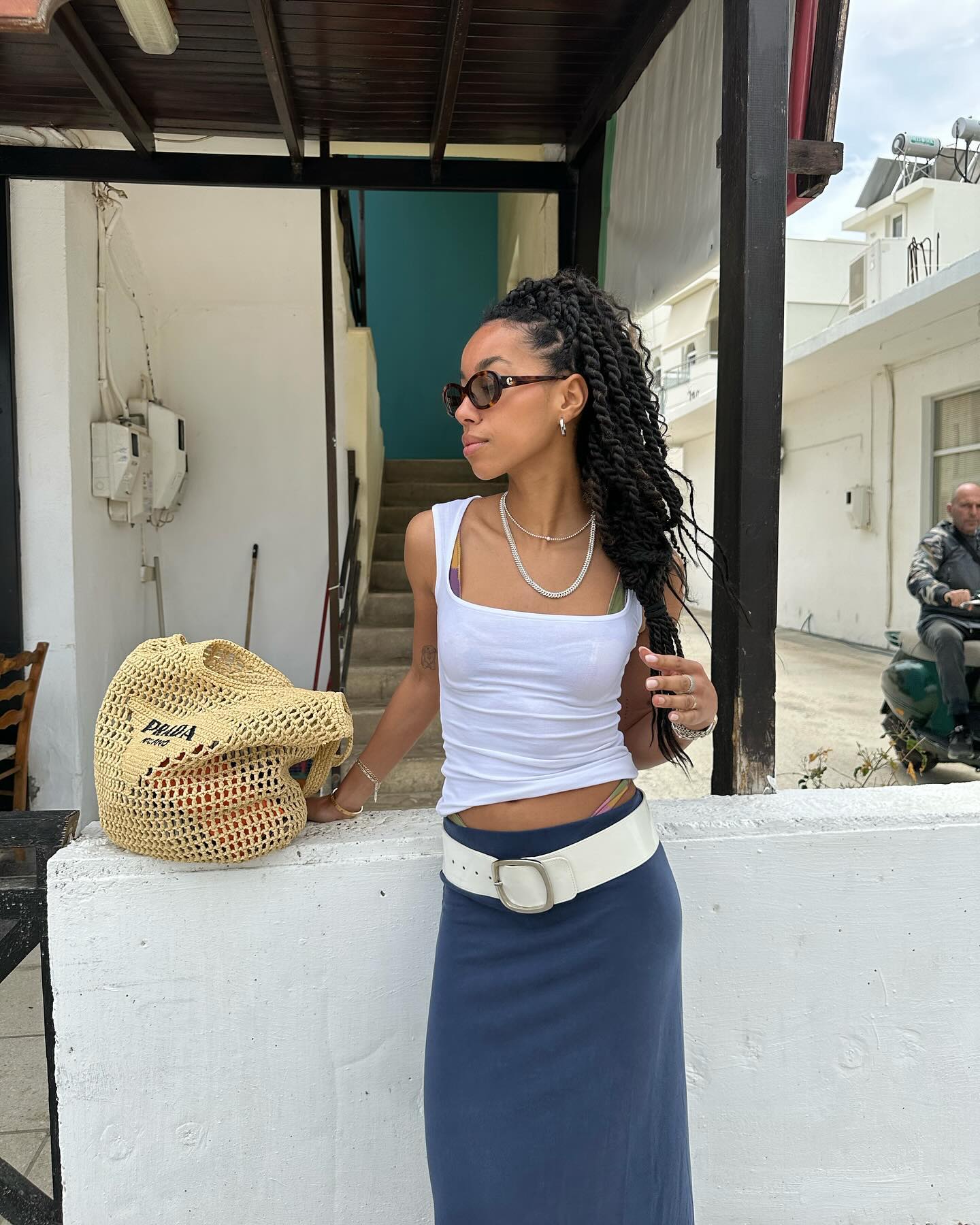 Amaka Hamelijnck posing next to a crochet Prada bag.