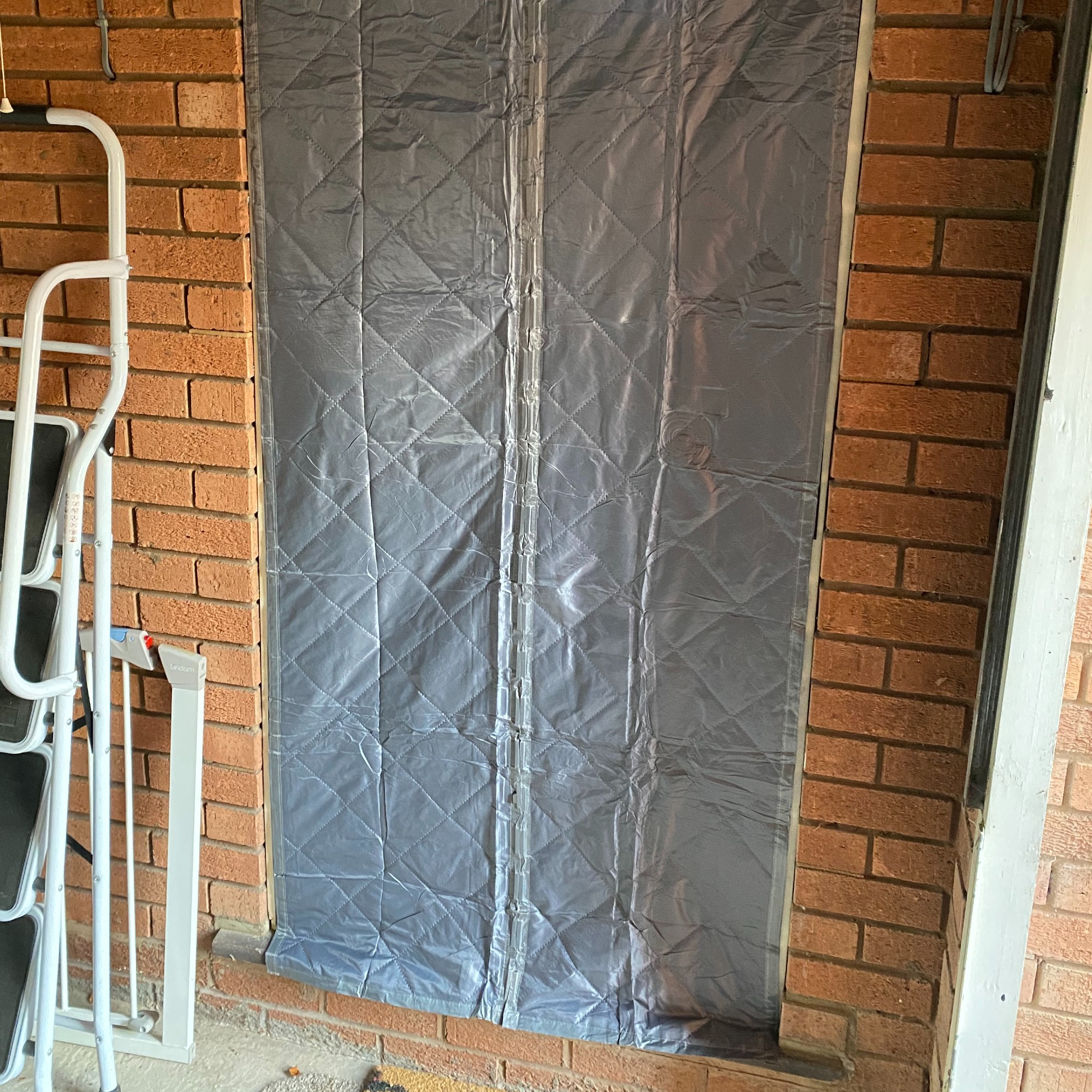 The insulated door curtain fitting to the exterior of the old door that goes from the kitchen into the garage