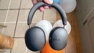 Sonos Ace headphones review listing image in black with balloons in background