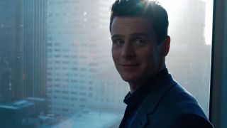 Jonathan Groff smiles in front of a window in The Matrix Resurrections.