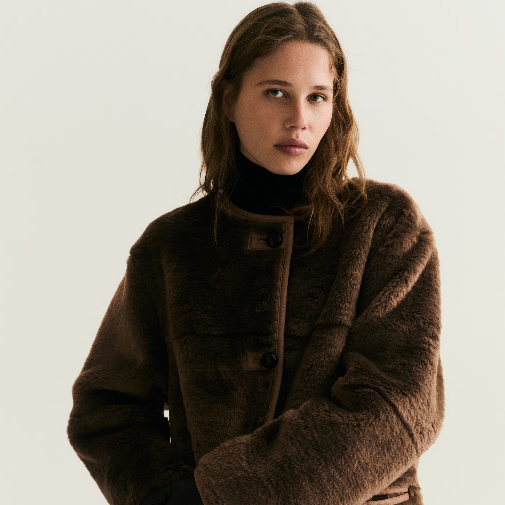 A model wears a brown coat from H&M.