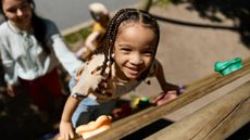 Portrait of smiling child climbing in a playground on sunny day