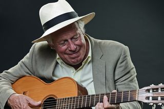 An older man plays guitar
