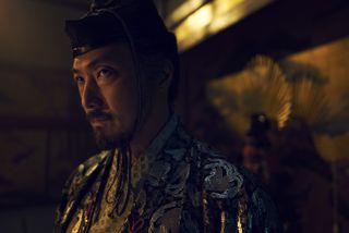 A close-up shot of Ishido Kazunari (Takehiro Hira), wearing fine robes with silver detailing