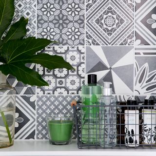 Grey patchwork tiles on splash back with green pot plant