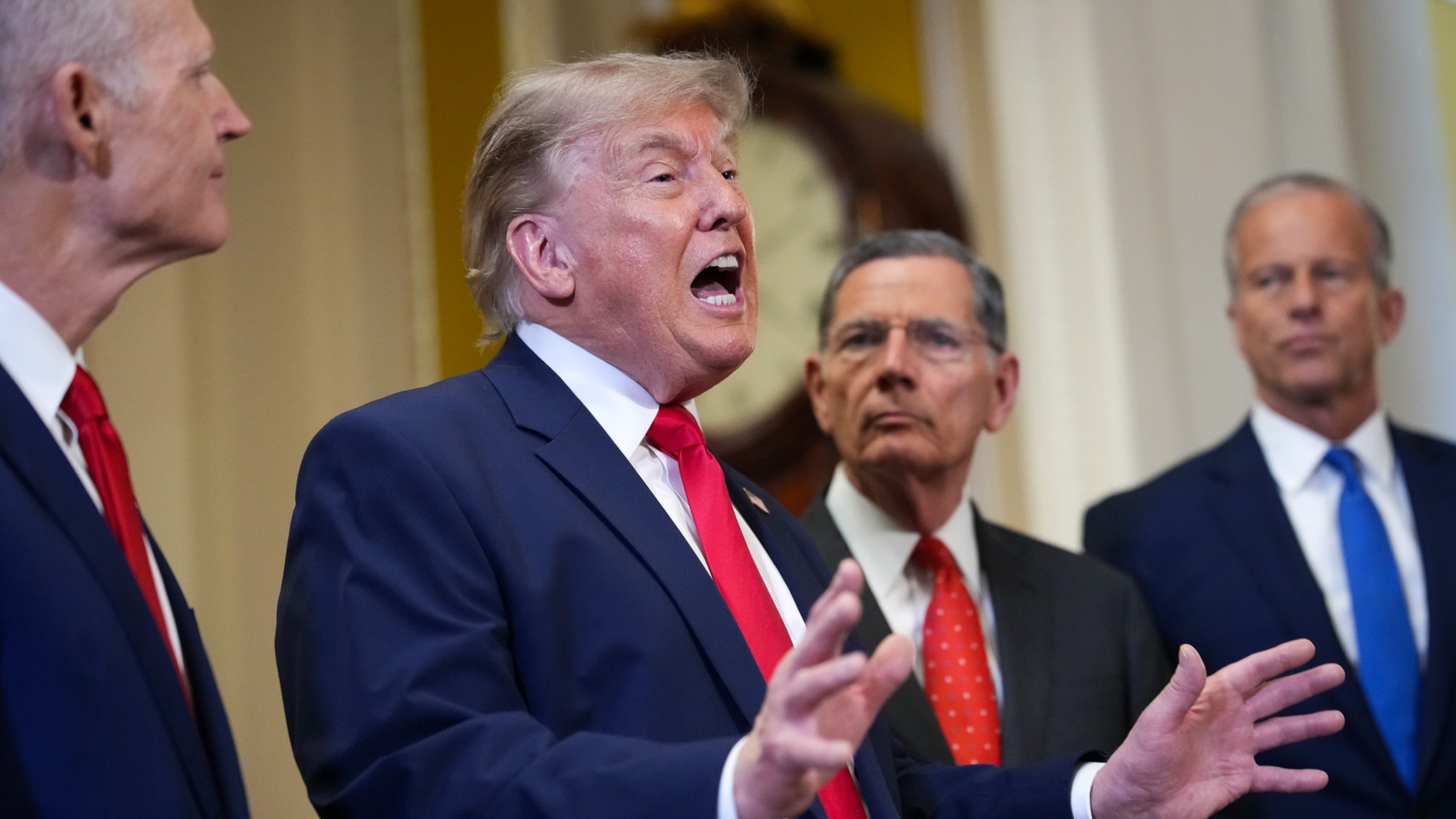 President Donald Trump speaks to the media with hands and mouth open