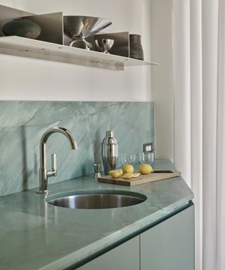 Aqua kitchen with under mounted round sink and open steel shelving