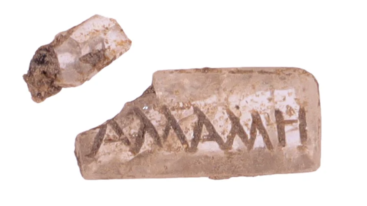 two fragments of a rose-colored stone inscribed with the Greek letters &amp;Alpha;&amp;Lambda;&amp;Lambda;&amp;Alpha;&amp;Lambda;&amp;Lambda;&amp;Eta; (Allall&amp;eacute;)
