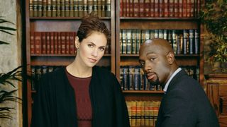 Amy Brenneman in a judges robe next to Richard T. Jones sitting on a desk in Judging Amy