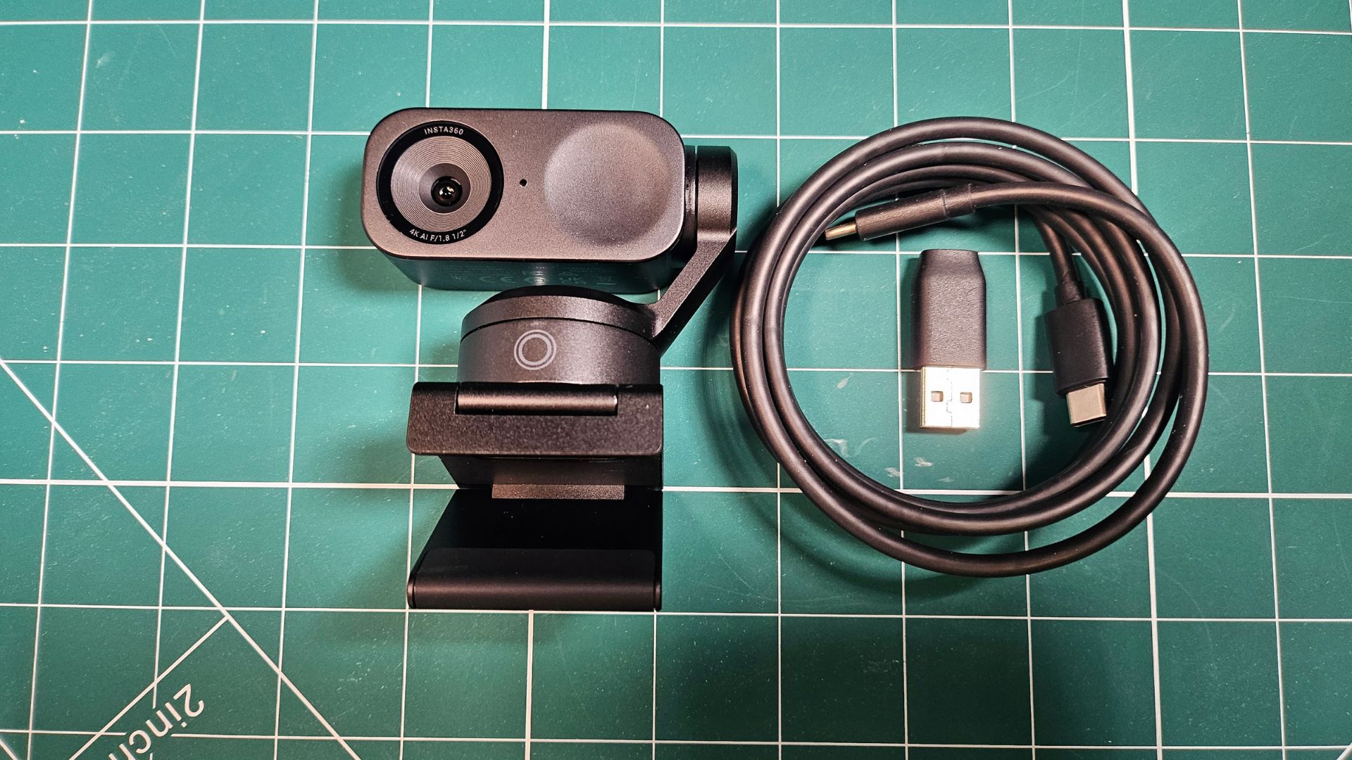 The Insta360 Link 2 next to its included cable
