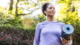 Woman holding yoga mat for tabata workout