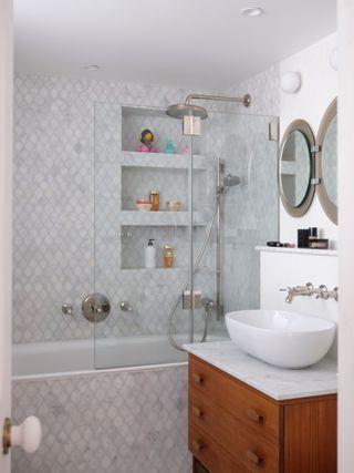 Marble tiled bathroom with built in shelving