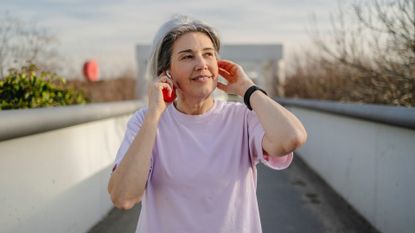 Woman doing walking HIIT workout as the best exercise for over-70s along path in city