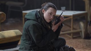 Ellie listening to a walkie-talkie radio in The Last of Us season 2 episode 7