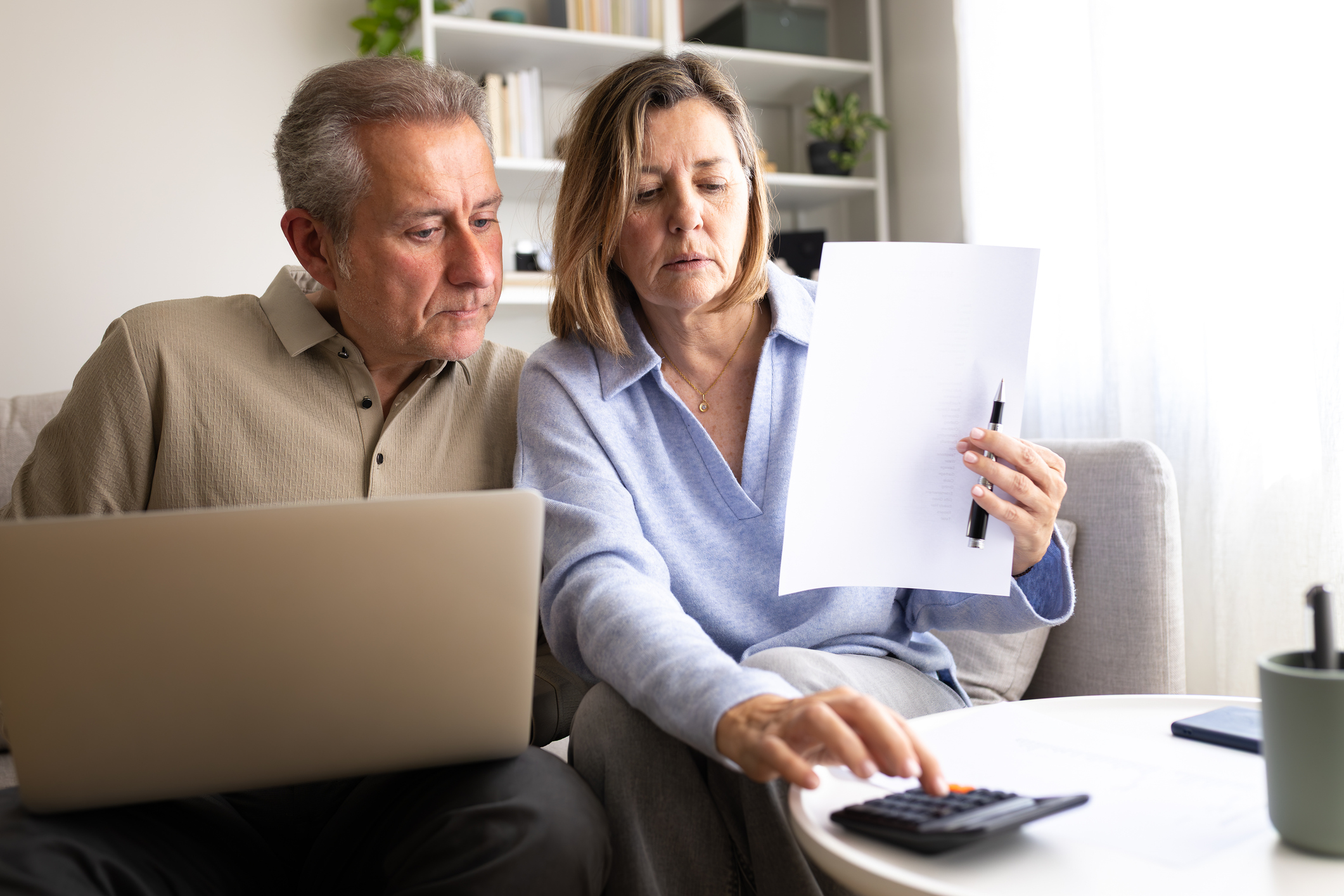 A couple with a laptop and calculator working out if a pension annuity is a good idea for them