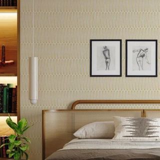 A bedroom with geometric white and yellow wallpaper