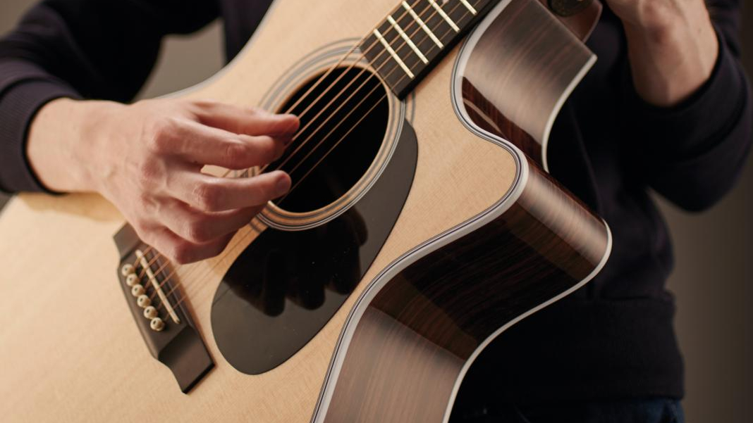 Close of Guitar Player team testing an acoustic guitar