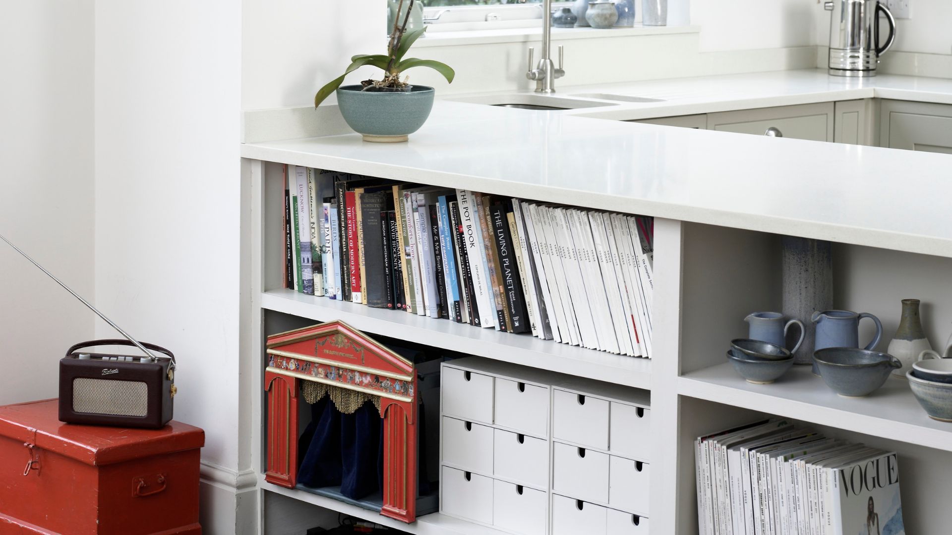picture of kitchen island with bookcases built in and various things stored inside