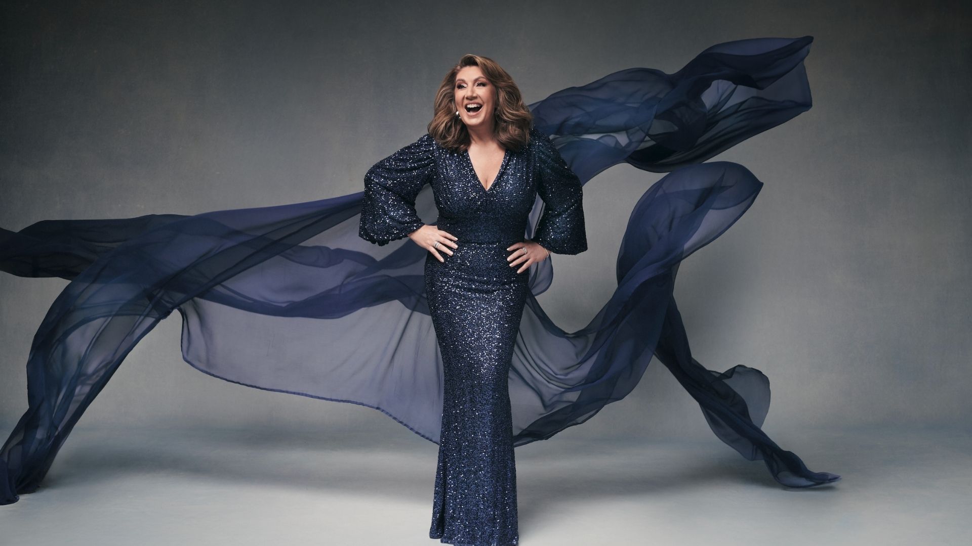 Image of Jane McDonald in a blue flowing sequin dress 
