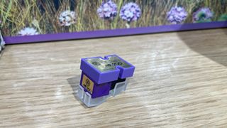 Nagaoka MP-200 moving magnet cartridge on wooden table in front of flower picture