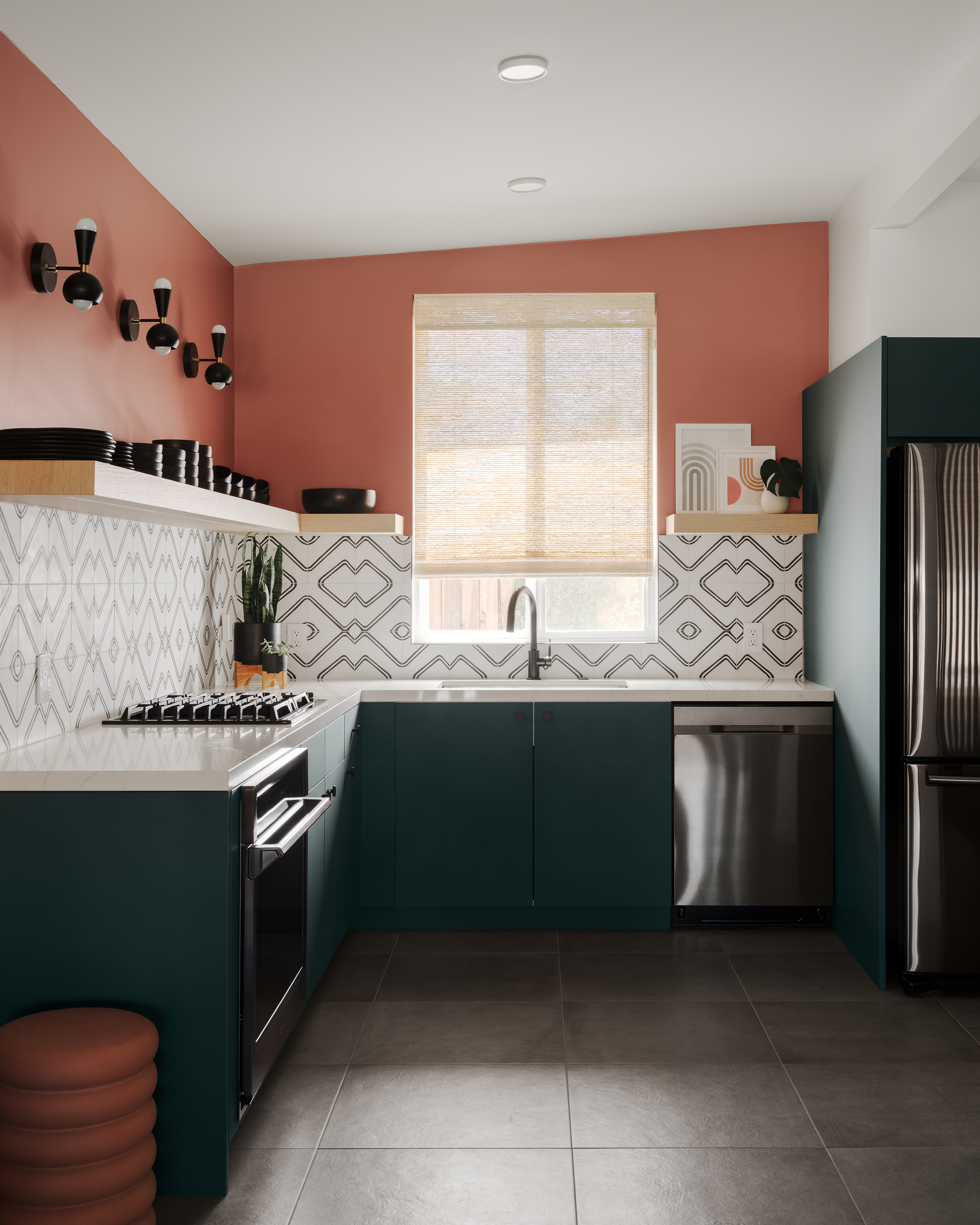 A kitchen painted in rust tones, with cabinets painted in green color