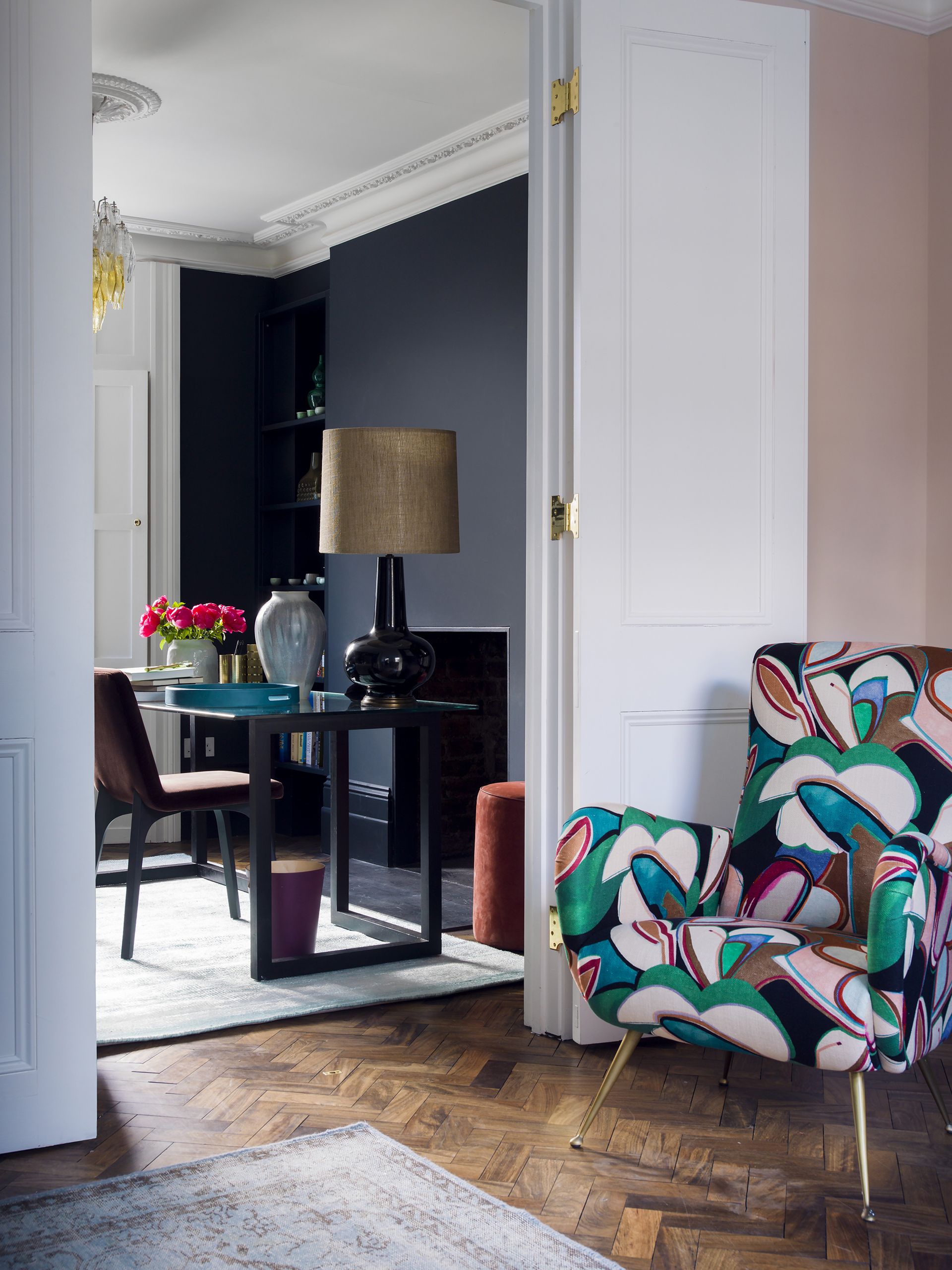 Home office with black walls off a living room