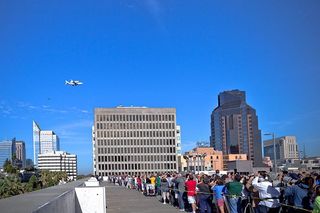 A crwod of onlookers watches NASA's space shuttle Endeavour and its carrier plane fly over California's capitol city Sacramento on Sept. 21, 2012, during a state-wide tour by Endeavour as the shuttle was delivered to Los Angeles for eventual display at th