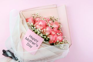 A bouquet of pink roses with a Happy Mother's Day card.