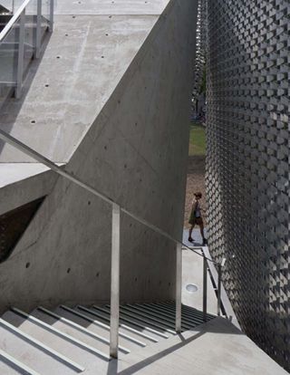 concrete stairway with metal screen wall
