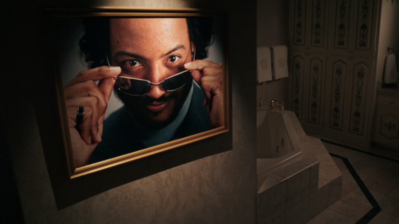 Koumba looking ocver glasses in portrait hanging in bathroom in Pluribus Episode 6