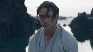 Manny Jacinto in The Acolyte as Qimir fresh out of the water with a towel draped over his shoulders