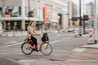 A woman commuting on an orange city bike