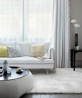 A white living room with white leather sofa and yellow cushions