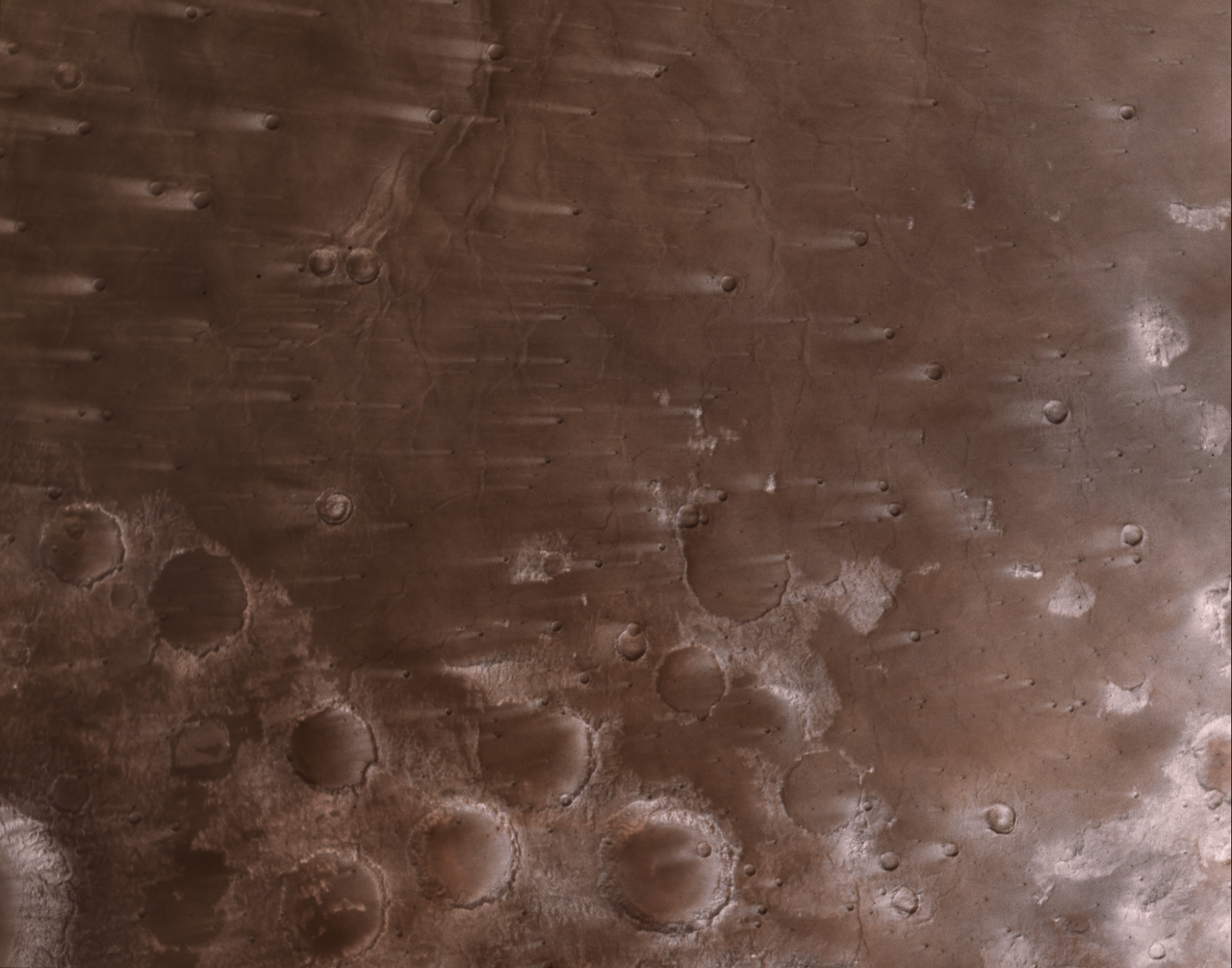 An image of Mars captured by NASA's Psyche spacecraft shows wind-blown craters on the surface of the planet